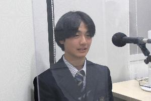 灰野さんが、マイクに向かって話しています。