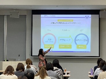 写真:広報物制作研修の様子。講師が資料をスライドに映して説明しているところ