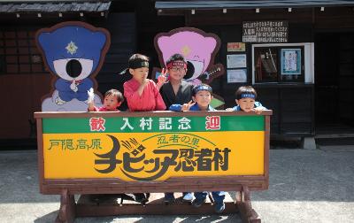 写真:チビッ子忍者村の入村記念看板の前で参加した子どもたちが忍者スタイルで並んでいます