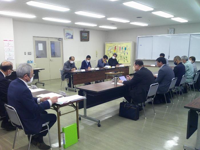 写真:会議室でロの字型に机を並べ、委員や市担当職員などが会議を行っています。