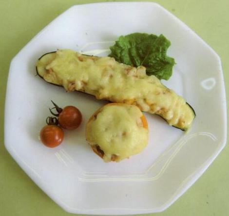 パプリカやじゃがいもの上に溶けるチーズをのせて調理されたパプリカカップという料理が白い皿の上に盛りつけられた写真