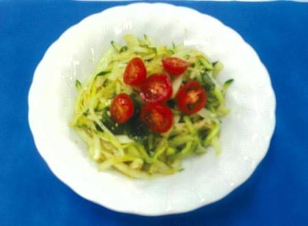 写真:皿に盛りつけられた新玉ネギのごまあえ。新タマネギに合わせたキュウリの緑色とミニトマトの赤色が色鮮やかです。