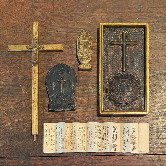 写真:小型の十字架や木製・金属製の宗教的道具や文書が並べられています