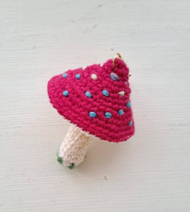 写真:赤いかさに水色の斑点模様のある編みぐるみのきのこ