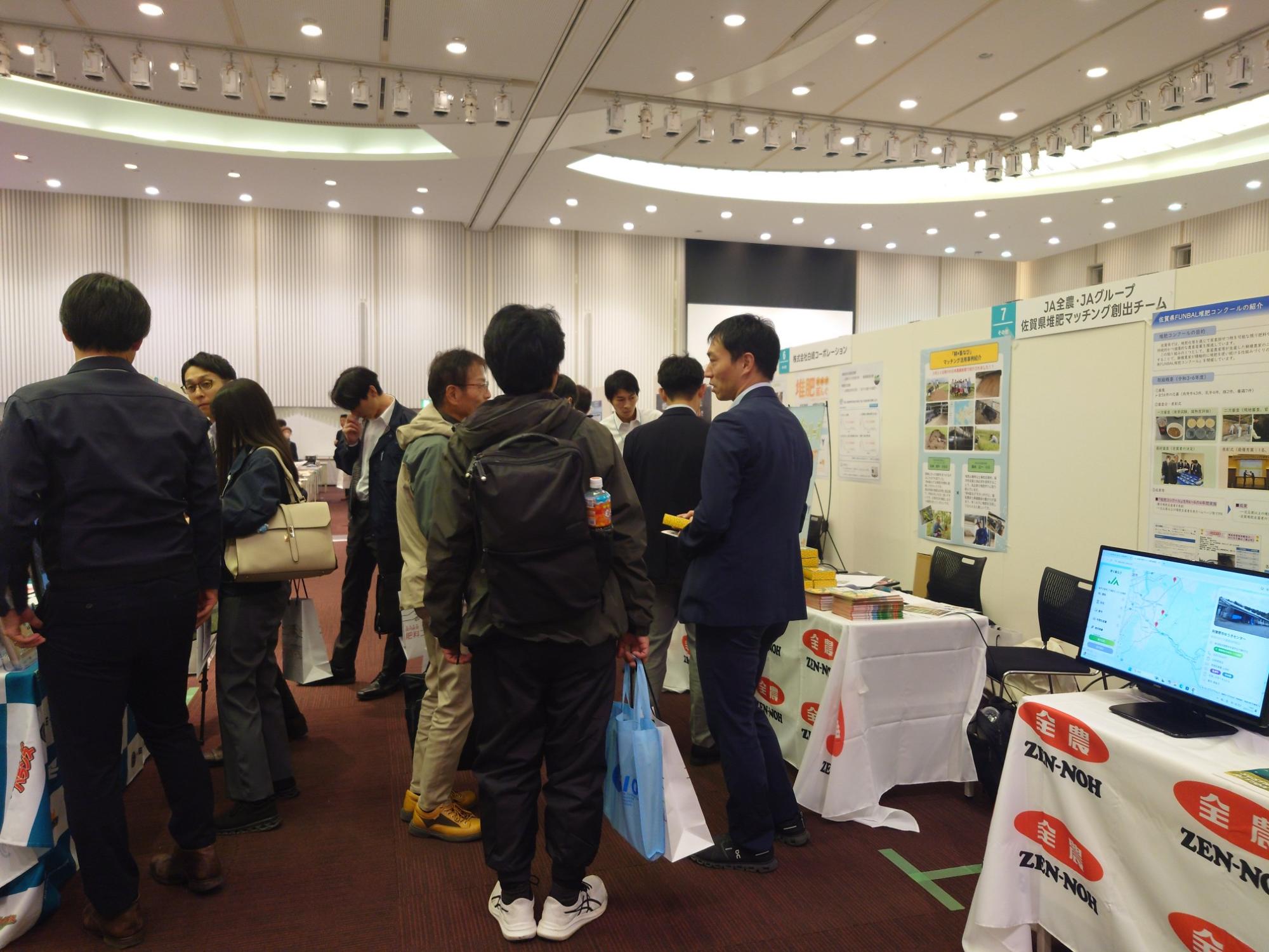 写真:全農ブースの前で担当者と会話をしている参加者
