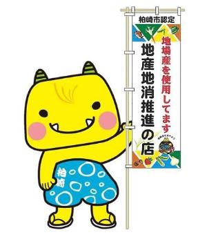 黄色い鬼のキャラクターのえちゴンが地産地消推進店ののぼり旗を持っている写真
