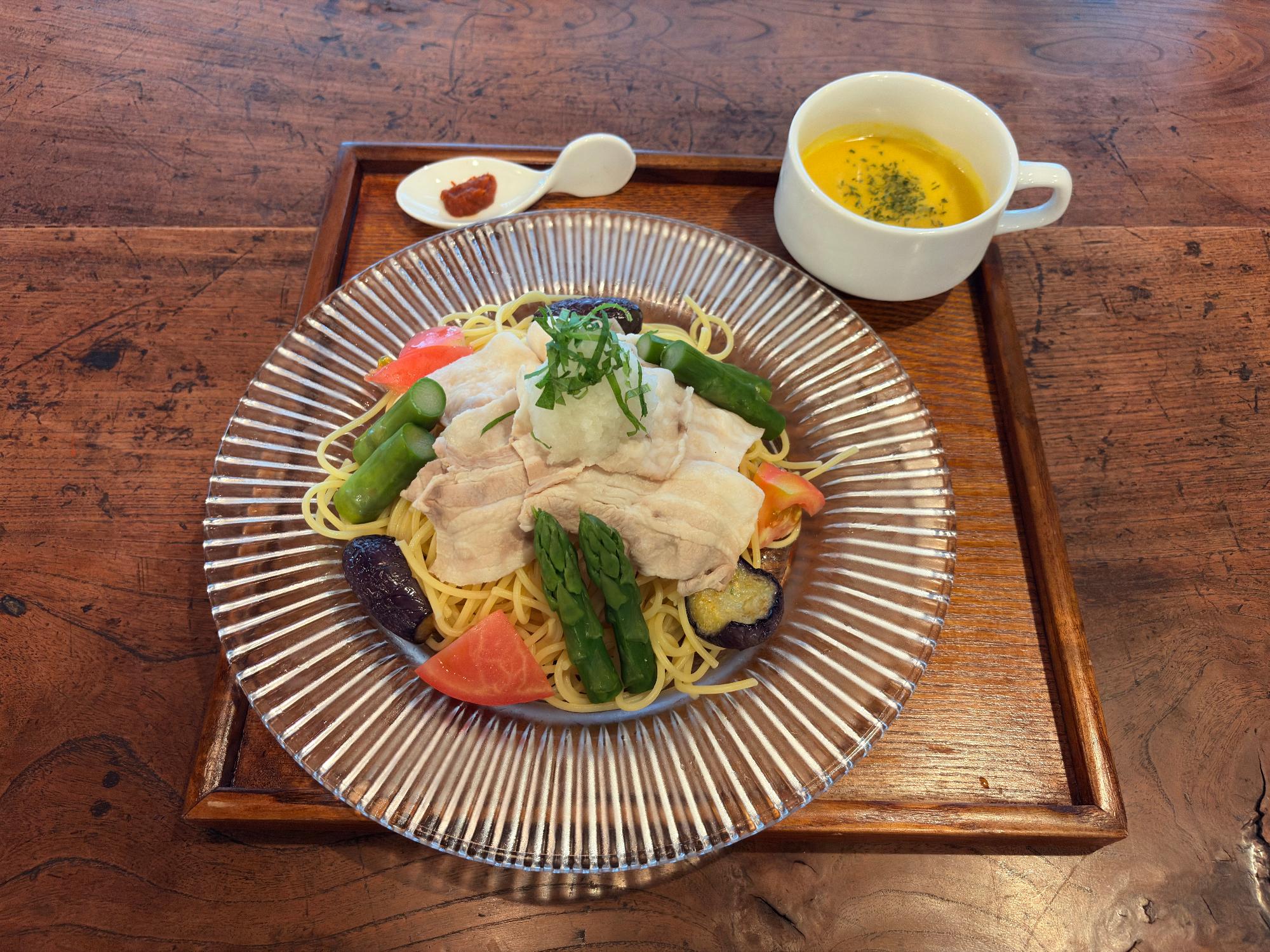 写真:妻有ポークを使用した冷しゃぶパスタ。パスタの上に妻有ポークが盛りつけられ、その周りにアスパラ、トマト、ナスが彩りよく添えられています。