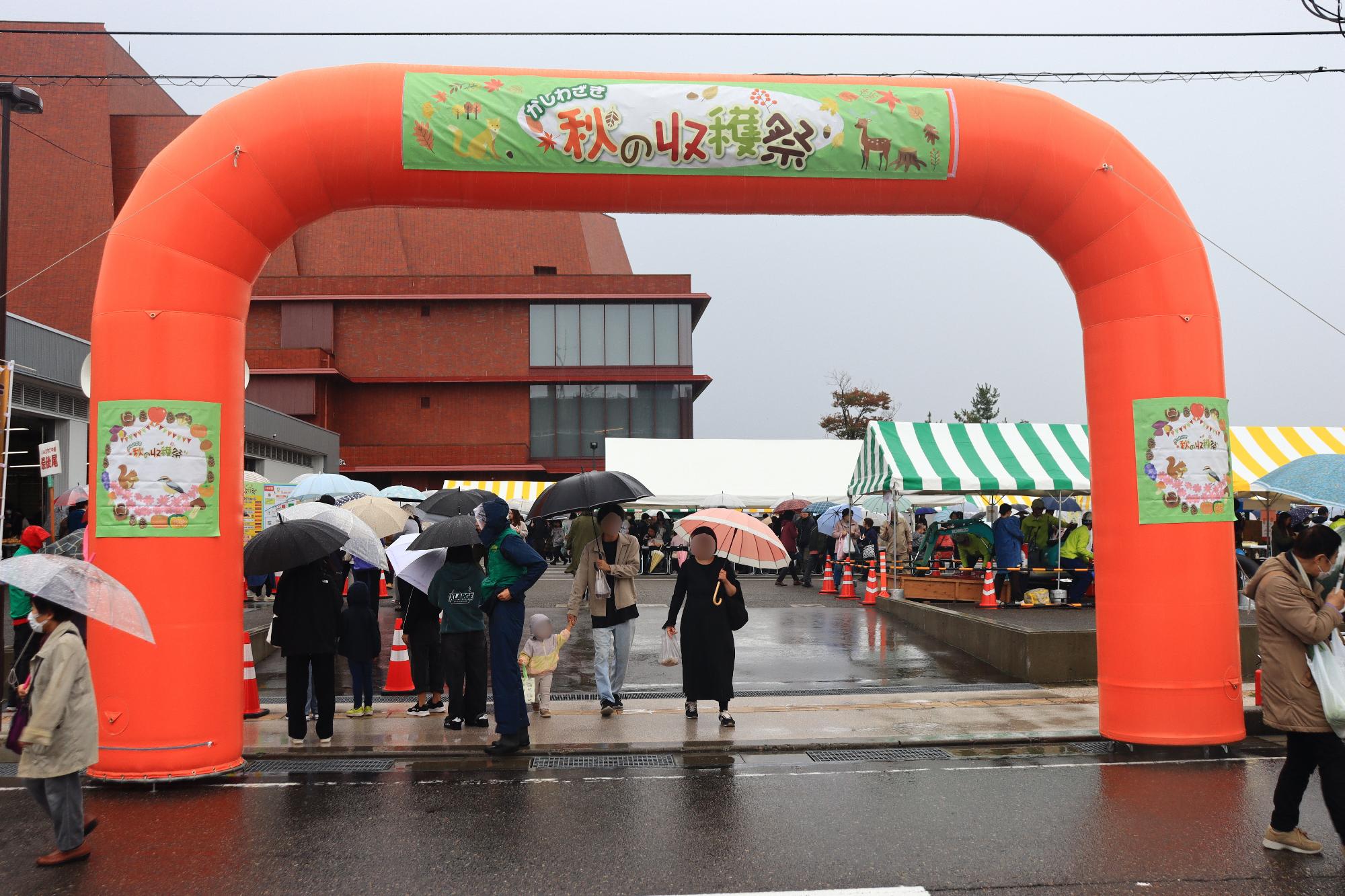 写真:昨年の秋の収穫祭の様子。秋の収穫祭と書かれた大きなアーチの下をたくさんの来場者が歩いています。
