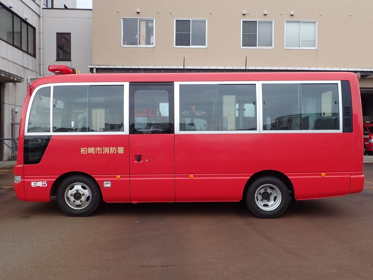 写真:車体に「柏崎市消防本部」「柏崎5」と表示された赤色のマイクロバス。左側のみを撮影しています