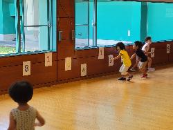 写真:子ども複数人が壁に貼られた数字を指示のとおりタッチしている様子です