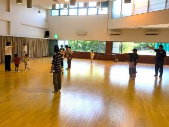 写真:参加者が円になり中央に立っている人とじゃんけんをしています
