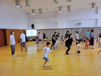 写真:参加者がスクリーンに表示された番号をタッチしようと走って向かっている様子です