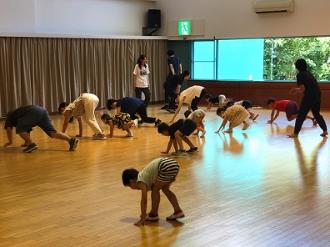 写真:参加者が四つん這いになって前進しています。膝をつかずに上手に進んでいます