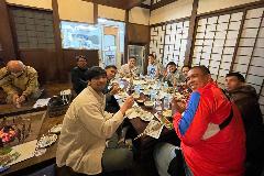 写真:高柳町の荻ノ島かやぶきの里で郷土料理を食べるフィリピンチーム