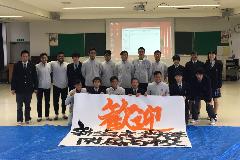 写真:記念写真です。最前列の選手・生徒が書道部の描いた「歓迎」の幕を持っています