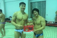 写真:香港の選手が産大男子水球部のキャプテンに香港チームのタペストリーを渡しています