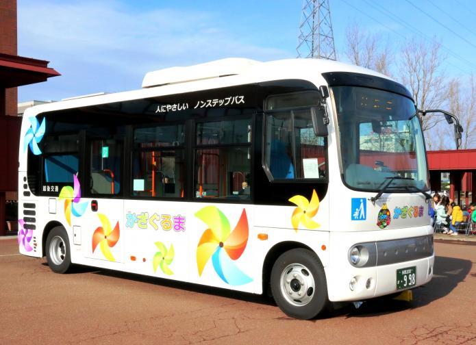白地に色とりどりのかざぐるまとシティセールスシンボルマークが描かれたバスの写真