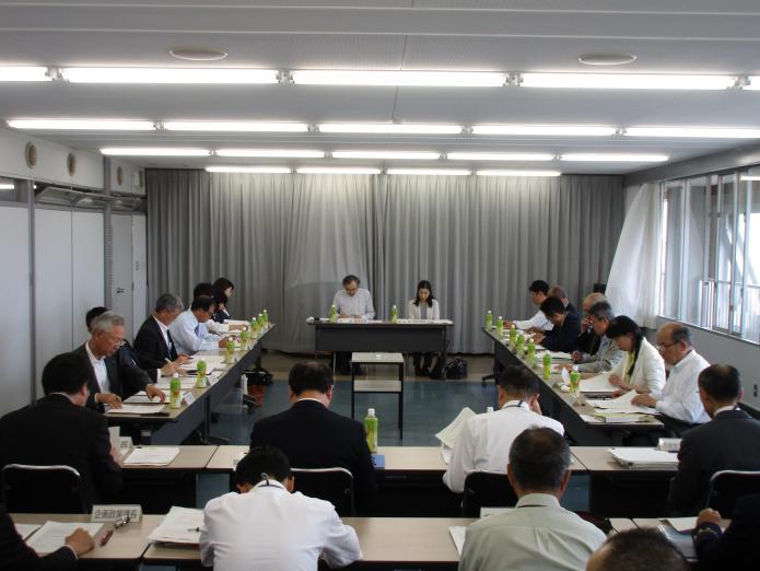 まち・ひと・しごと創生総合戦略推進委員会で事務局からの説明を聞く委員たちの写真