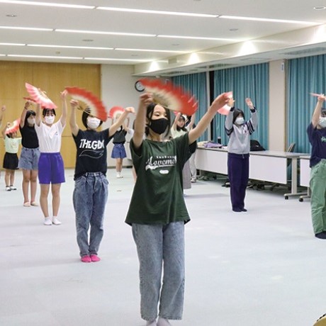 写真:小中学生が右手に扇を持ち、小歌踊の練習しています。