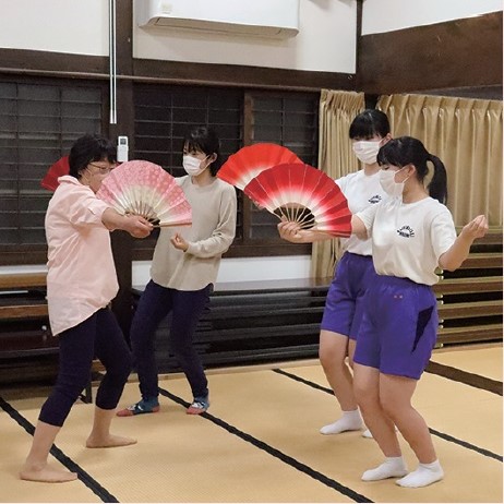 写真:練習する中学生の前で、実際に扇の舞の手を教える指導者の女性