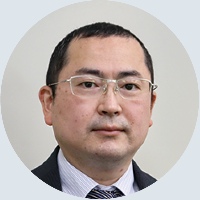 眼鏡をかけスースを着た男性の顔写真