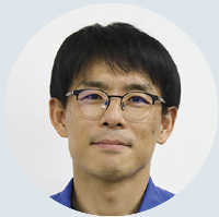 眼鏡をかけた作業着姿の男性の顔写真
