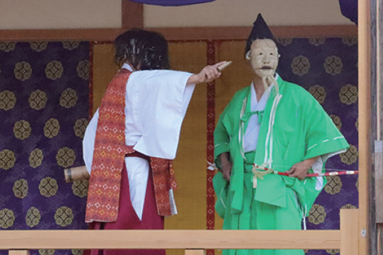 写真:1人の神様役が指をさし、もう1人の神様役はその方向を見ているます