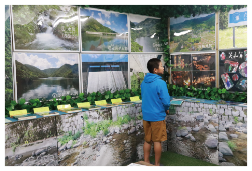 写真:水道やダムに関する写真などを展示している水のふるさと展示室を見学する辰尾くん