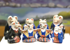写真:着物姿をしたネコの土人形が8体写っています。