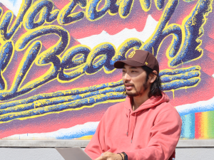 写真:セントラルビーチの小林さん(男性)がインタビューに答える様子