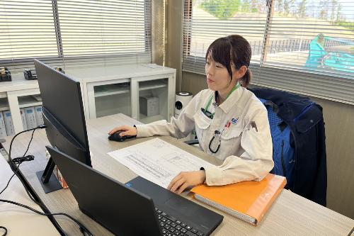 写真:自席でパソコンに向かって作業する橘さん