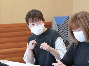 写真:会議で意見を話す女性