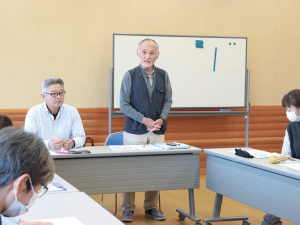 写真:くらサポの会議で立ち上がって話す男性