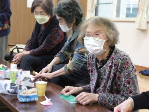 写真:折り紙を折ったり、隣の人の出来を見たりしながら和気あいあいとする参加者