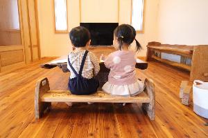 木製のベンチに2人の子どもが座っています。