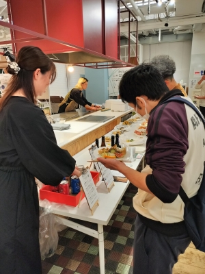 写真:来場者にドリンクを提供する猪浦さん