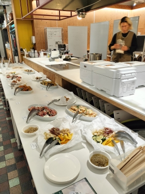 写真:カウンターに並べられた数々の料理。奥には中村さんが準備をしています