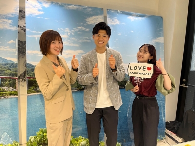 写真:トークゲスト3人が、緑濃い米山・赤い米山大橋・青い日本海が映ったパネルの前に並んでいます