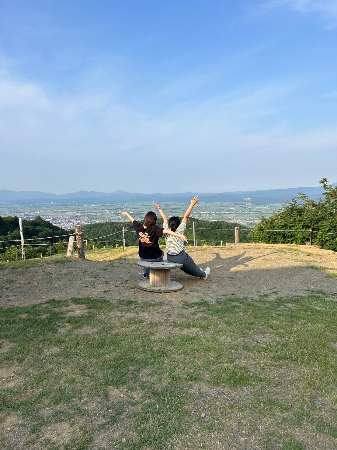 写真:プライベートで市街地を一望できるスポットを訪れた田川さん。友人と二人で思い切り手足を伸ばしています