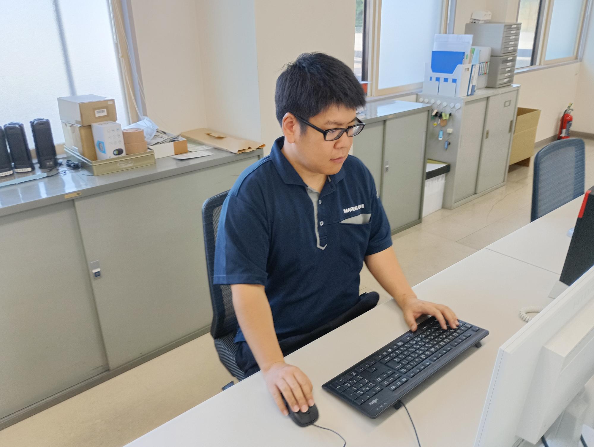 写真:パソコンに向かう勤務中の橋本さん