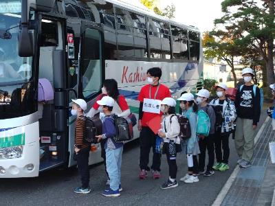 写真：保護者に引き渡せなかった児童のバス避難の様子。小学校の教員が誘導しています子
