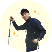 写真：両手にストックを持ち、山を登る真似をする古嶋さん