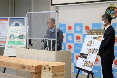 東京2020オリンピック・パラリンピック選手村ビレッジプラザで使用した木材から制作したベンチの説明をする柏崎木材協会の太田会長