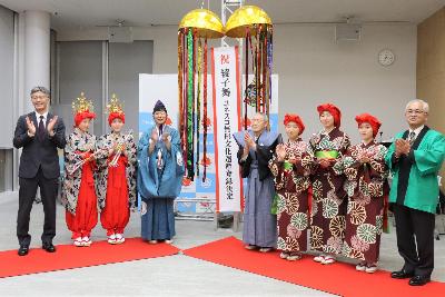 綾子舞のユネスコ無形文化遺産登録決定のくす玉を割る市長、柏崎市綾子舞保存振興会の高橋会長、高原田保存会の猪俣座頭、下野保存会の関座頭、踊り手5人