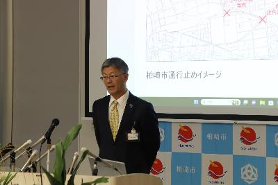 写真：市内の地図をスクリーンに映し、地震発生時の通行止めについて市長が説明しています。