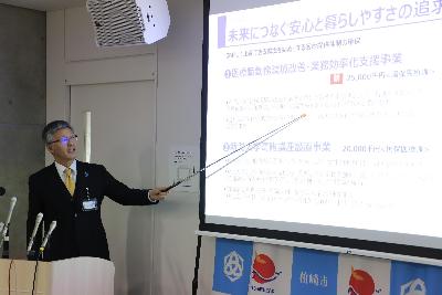 写真：市長がスクリーンを使いながら説明しています。