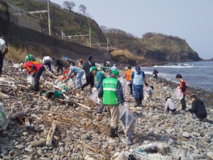 海岸のゴミを拾う人たちの写真