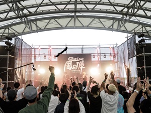 たくさんの人が音楽のライブを楽しむ様子の写真