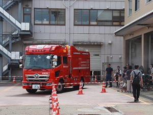 走る消防車を見学する参加者の写真
