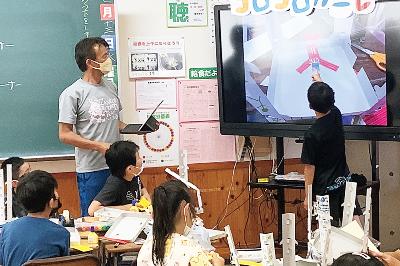 写真：電子黒板を使って児童がクラスメイトに説明を行う様子